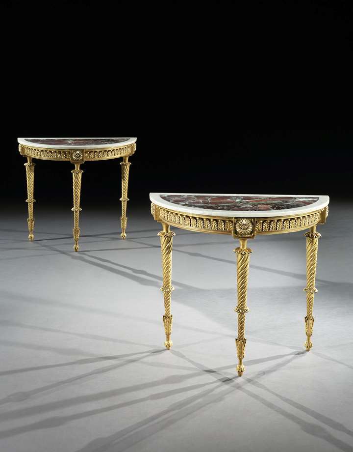 A pair of demi-lune giltwood side tables